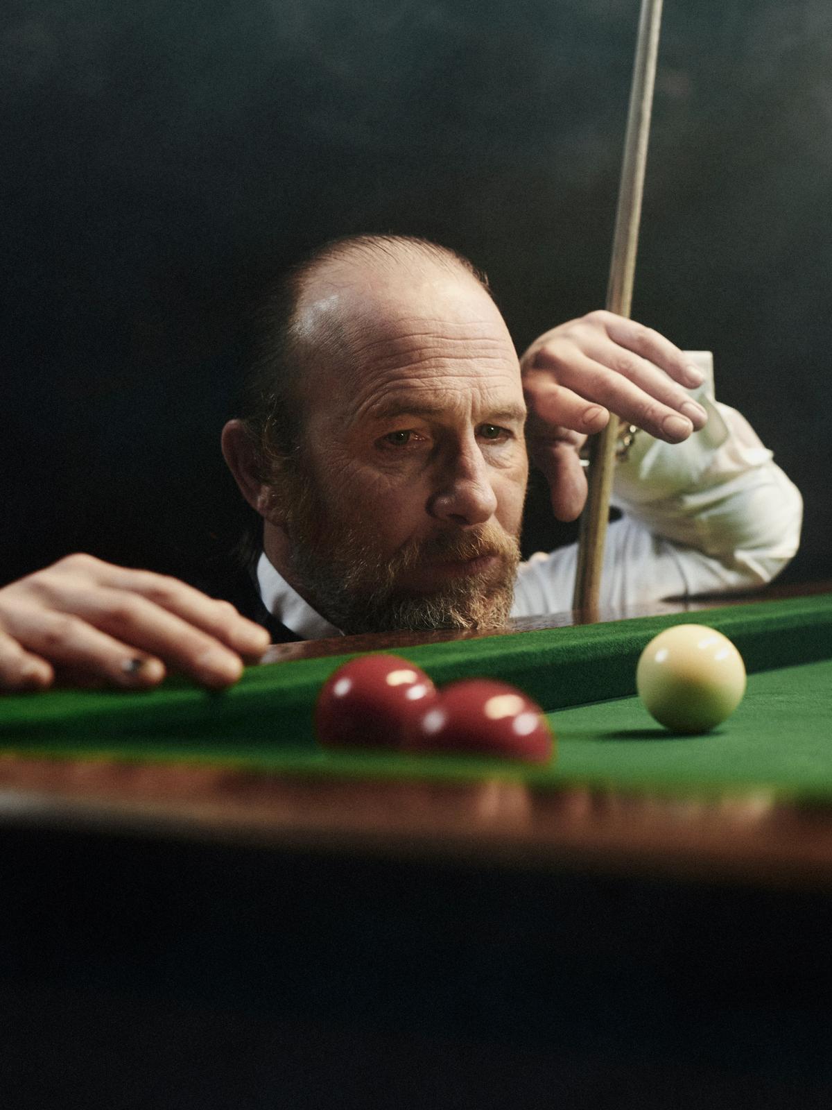 LOUIS-JACK snooker film player paul kaye looking at billiards balls with cue in hand