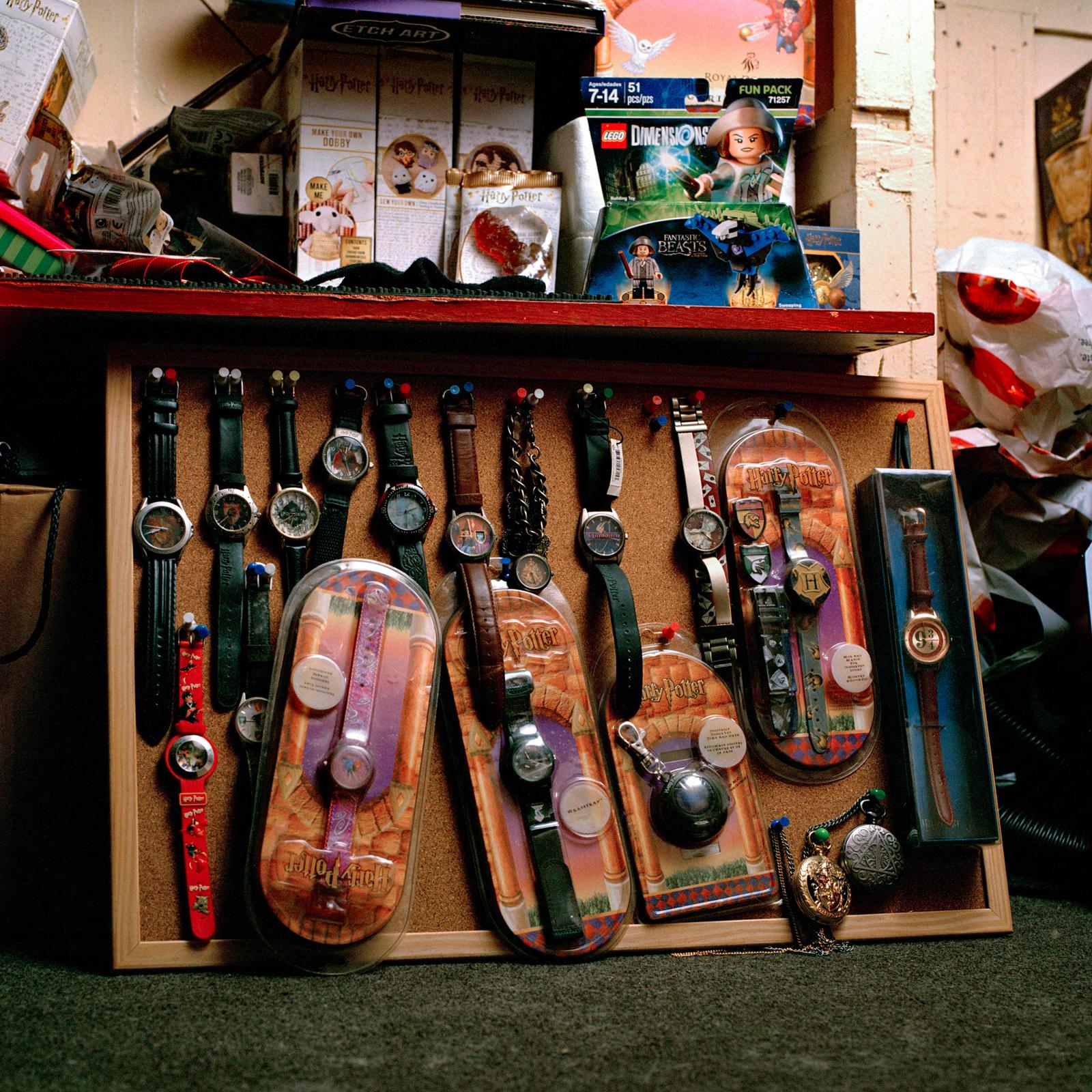 A collection of Harry Potter-themed watches and accessories featuring a Hogwarts crest, a wand shape, and a character face.