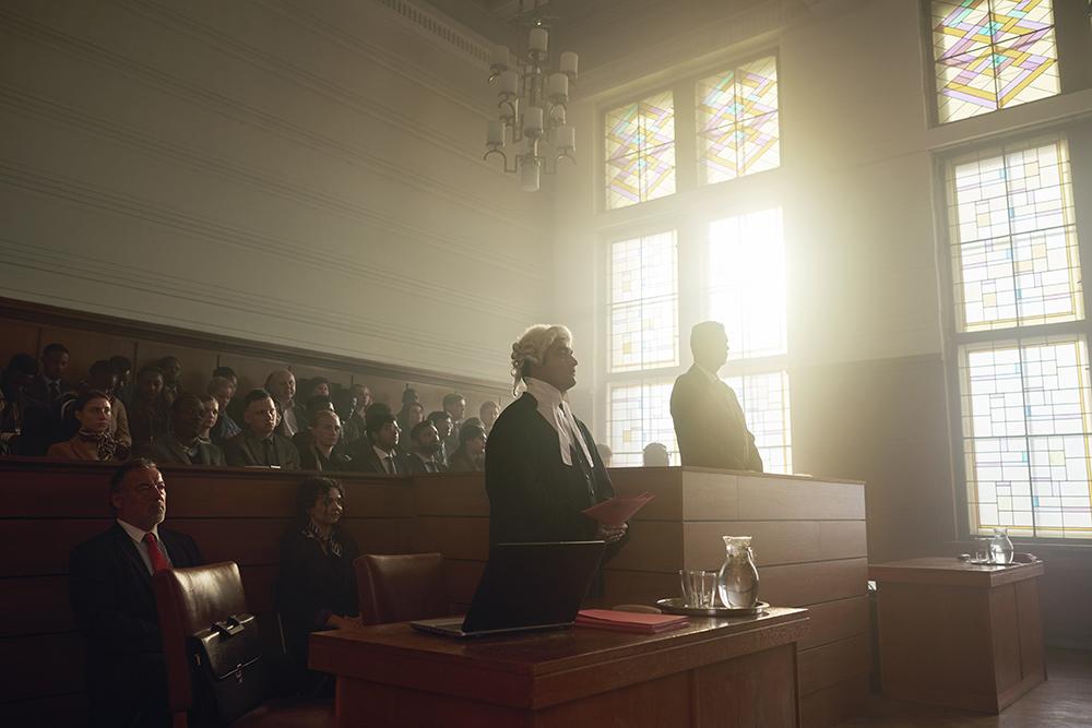 A courtroom scene with a judge, a lawyer, and a jury in a traditional, old-fashioned courtroom setting, with a judge's bench, a jury box, and a courtroom audience.
