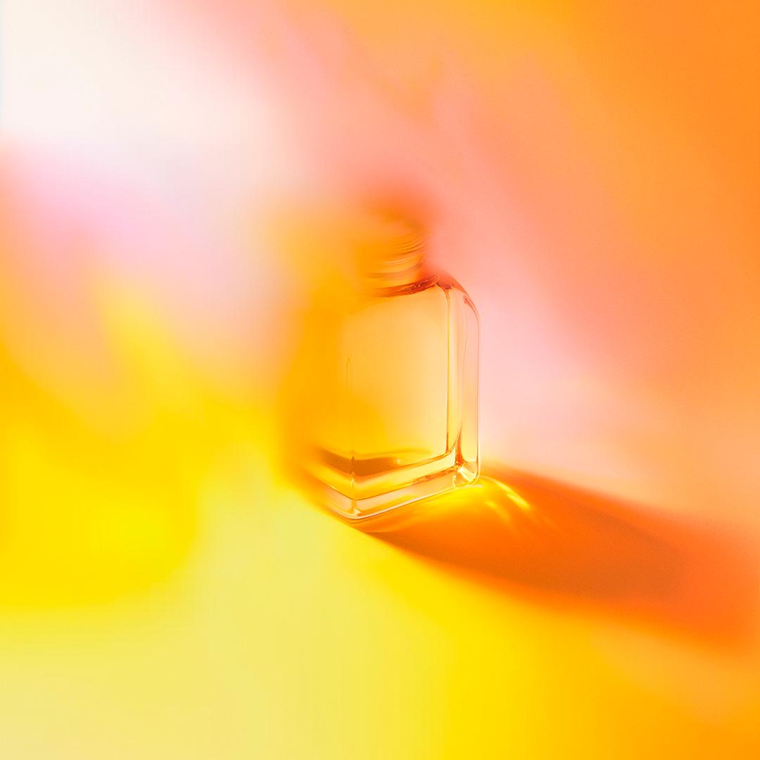 A delicate, hand-blown glass vase with a unique, swirling pattern of red and gold, reminiscent of a fiery sunset.