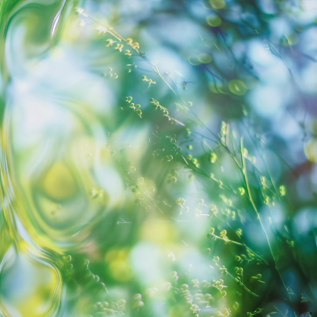 A close-up of a green, glowing, iridescent, and abstract, swirling, liquid-like substance, with a few, small, yellow, glowing, sparks or particles, scattered throughout.