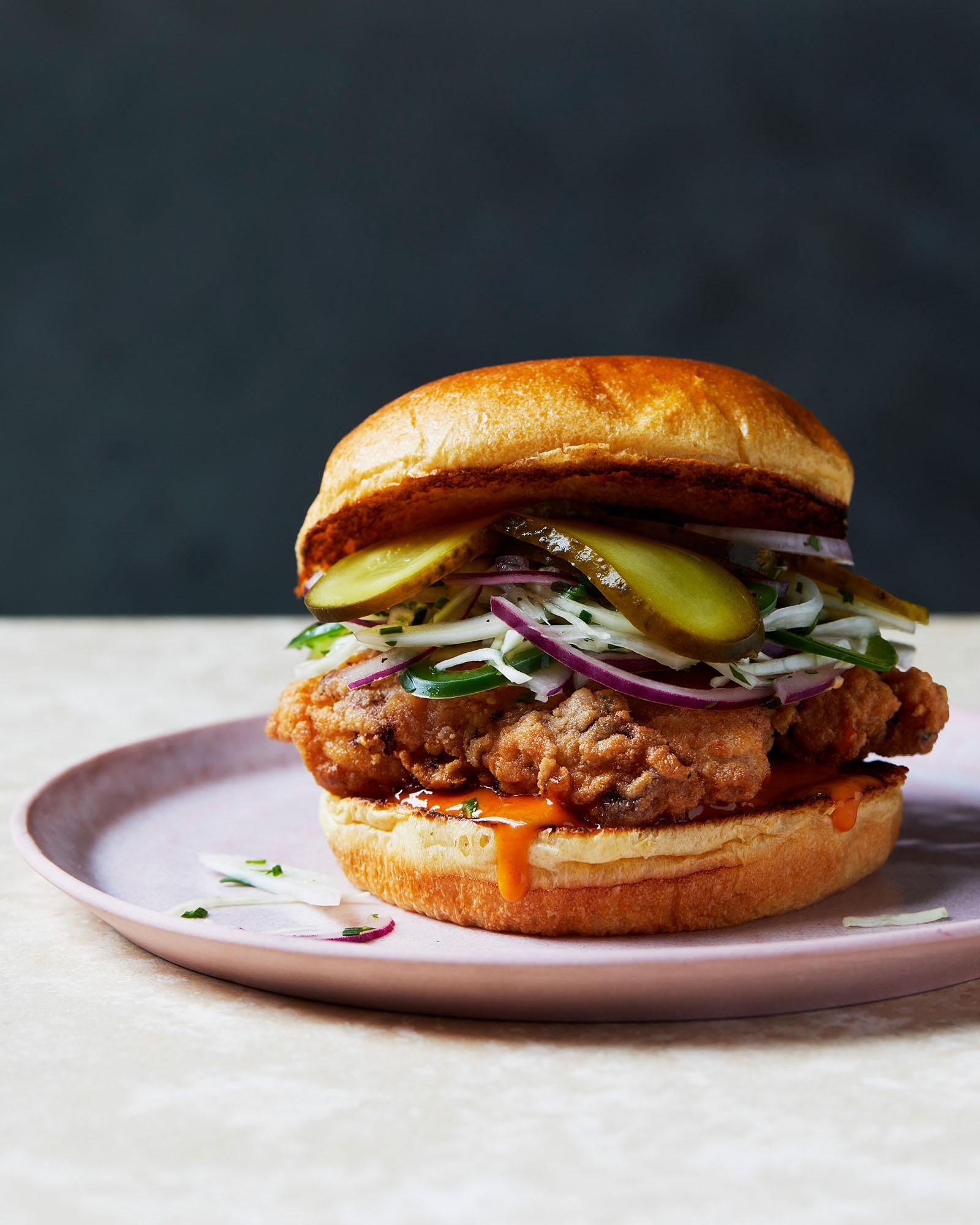 A crispy, golden-brown chicken sandwich on a toasted bun with a fried chicken breast and other toppings.