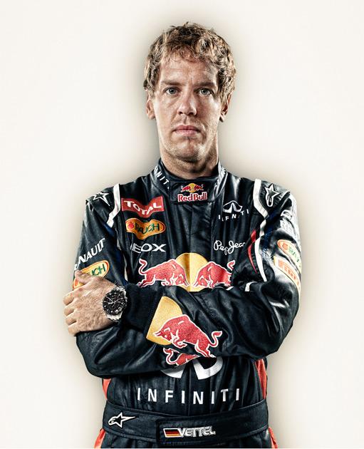 A man in a black racing suit with multiple sponsor logos.