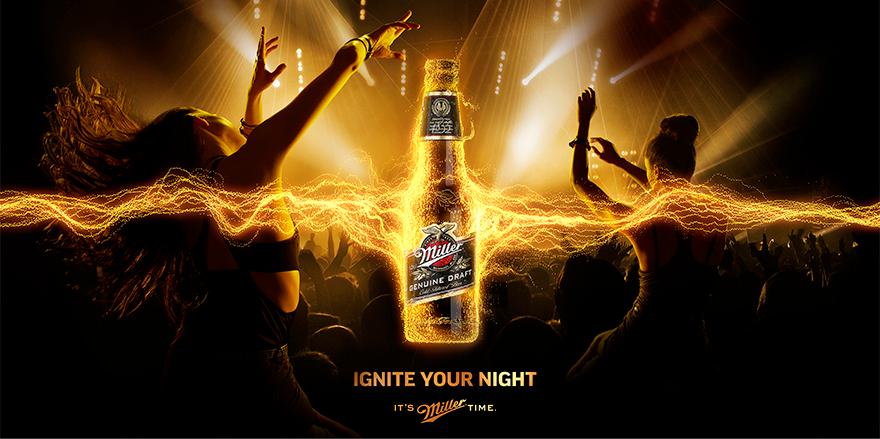 A woman with long hair is dancing in front of a stage with a Miller beer bottle in the background, surrounded by a yellow and orange glow.