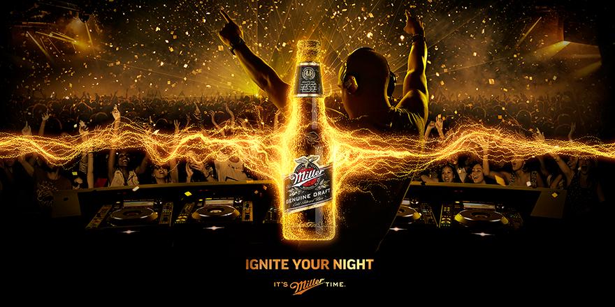 A DJ with hands in the air, surrounded by a crowd and a large screen, with Miller beer bottles visible.
