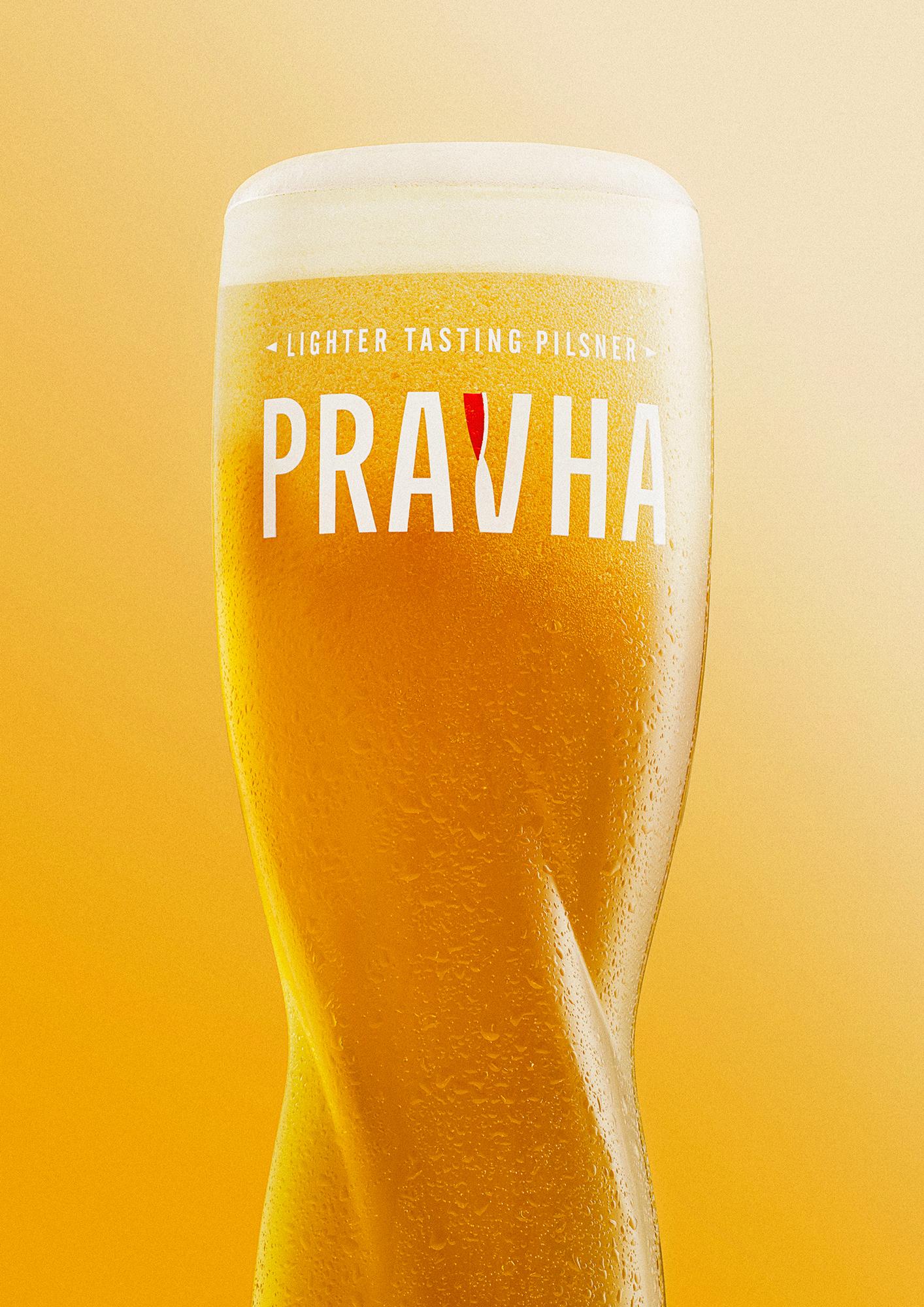 A glass of Pravha, a lighter tasting pilsner, with a golden yellow color and a white head.