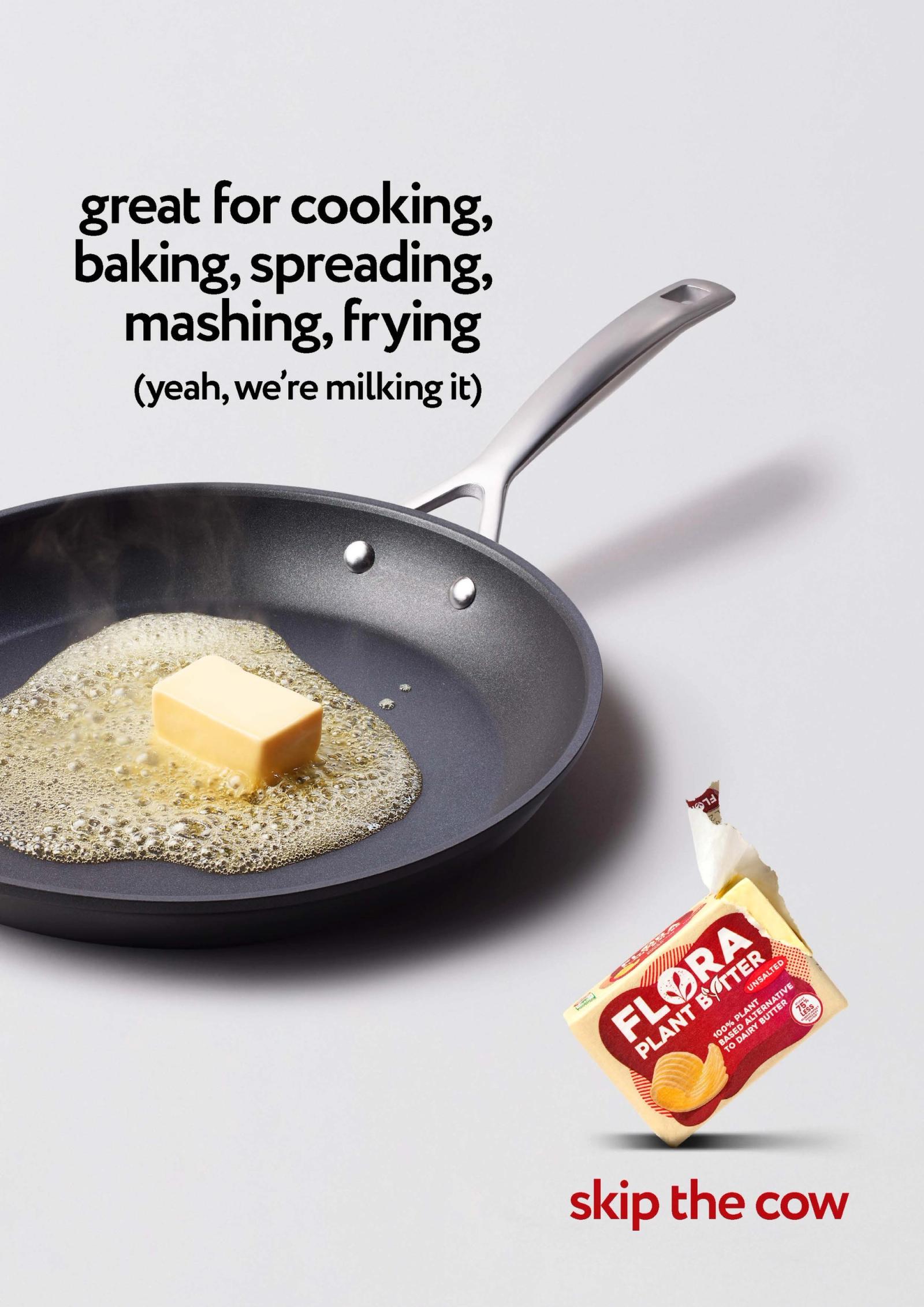 A frying pan with a block of Flora butter melting in it, with a spoon in the background.