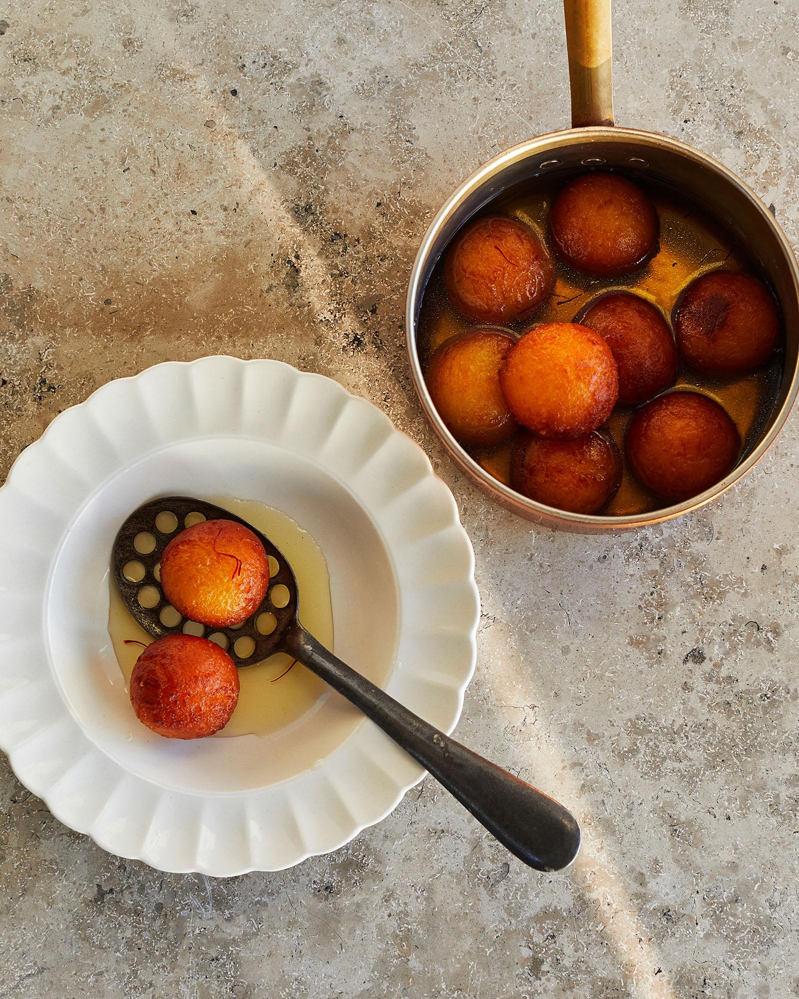 A bowl of fried, sweet dessert balls called gulab jamun.