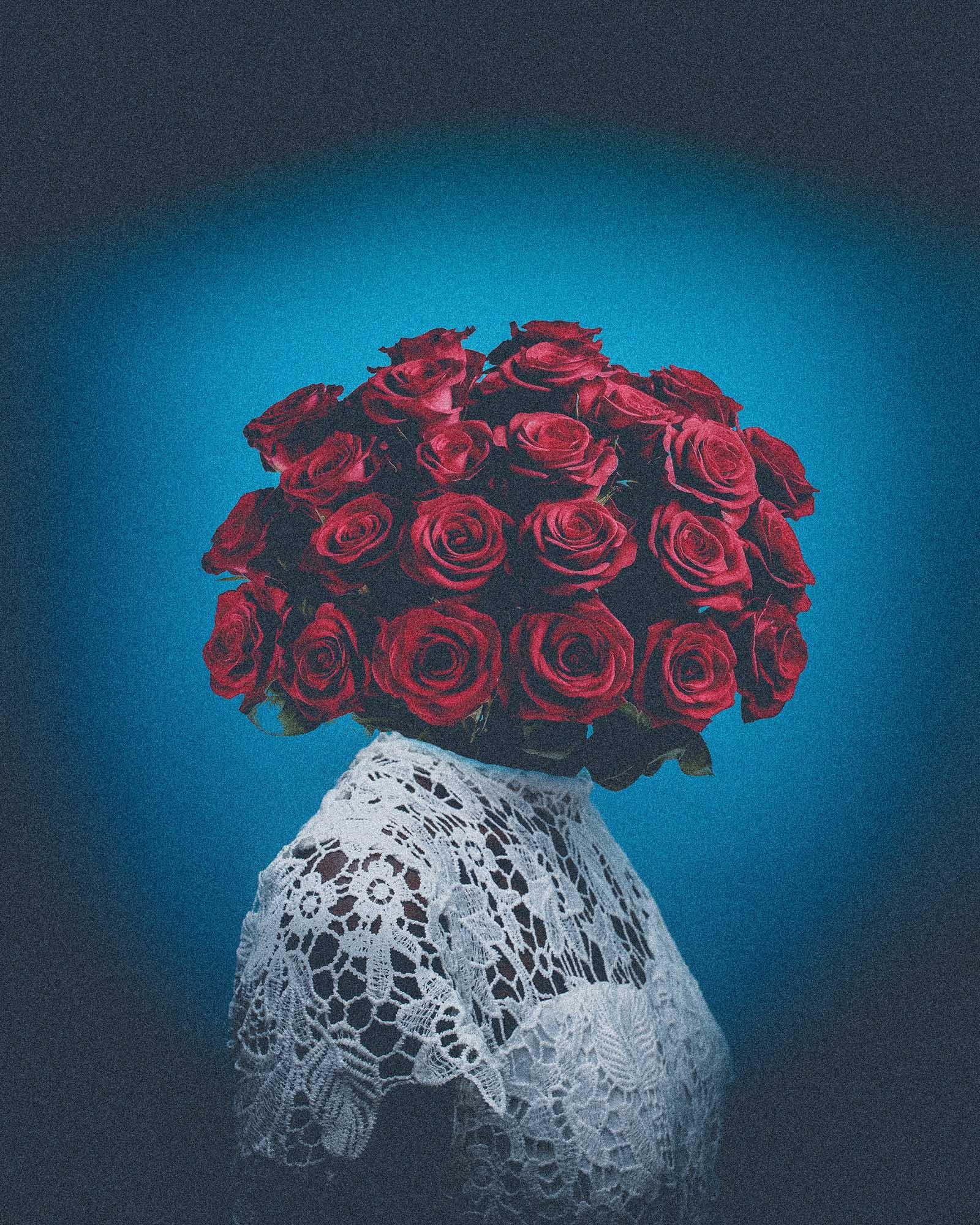 A bouquet of red roses in a white lace-covered vase.