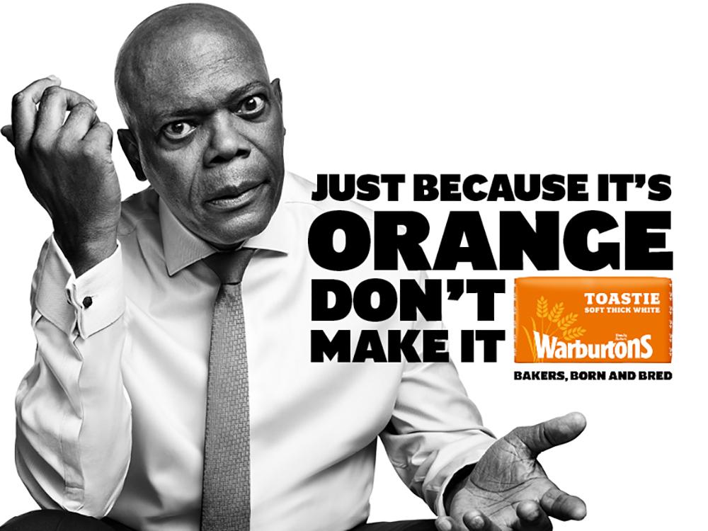 A man in a white shirt and tie holds toast and an orange slice on a white background.