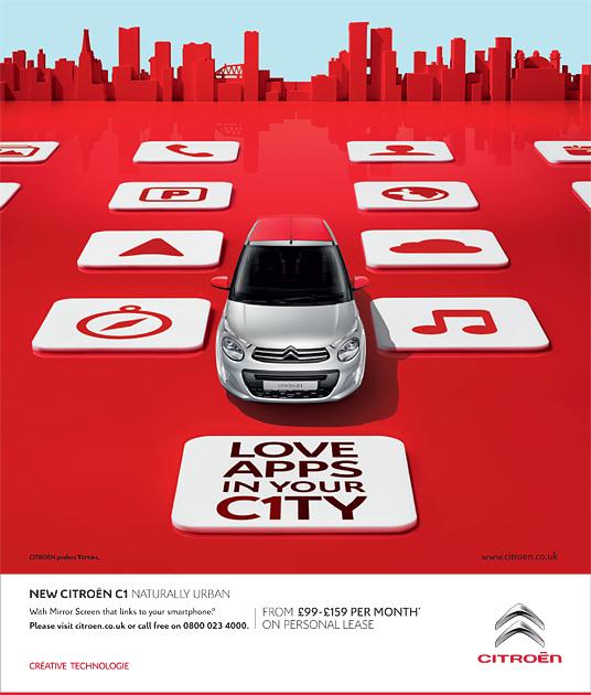 A Citroen car driving through a city with screens displaying various applications.