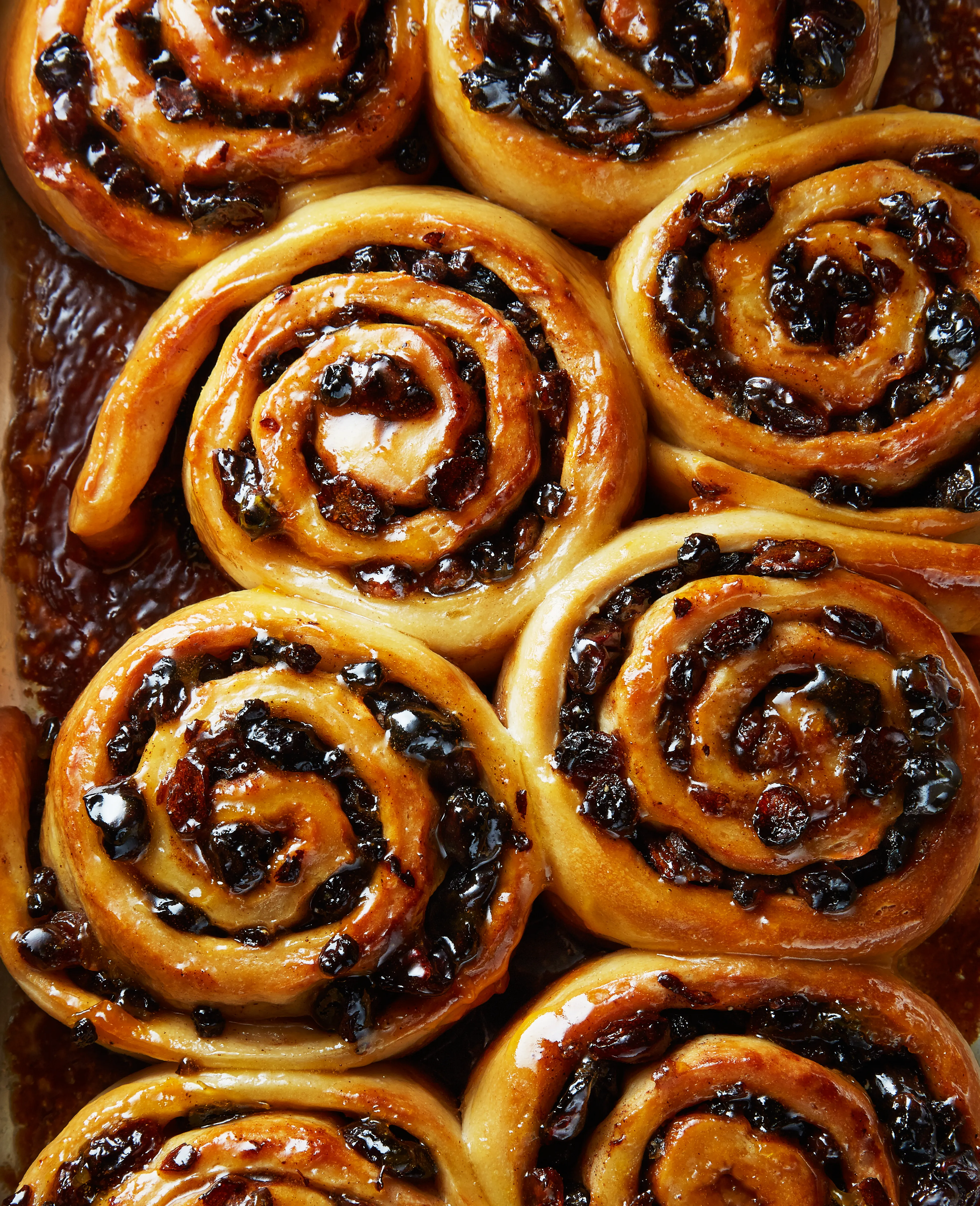 A close-up image of a baking tray filled with golden-brown, spiral-shaped pastries.