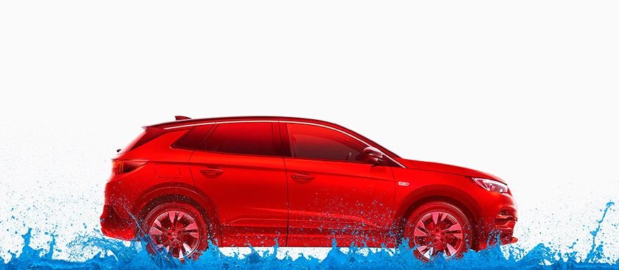 The image features a red car with a splash of blue paint or water splashing up from the bottom of the frame, creating a dynamic and energetic effect. The car is shown in profile,.