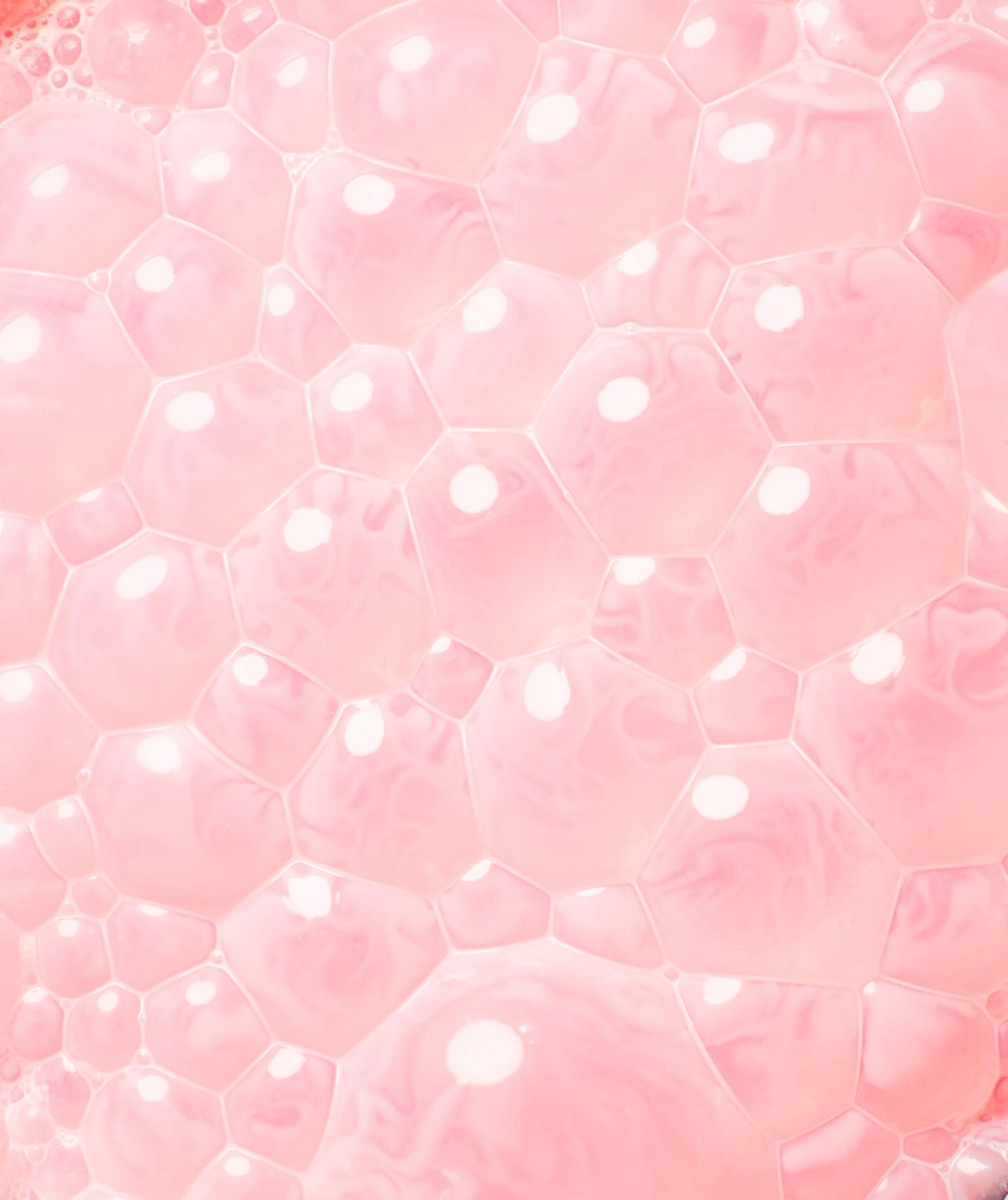 A close-up of a pink, soap-bubble-like, hexagonal patterned surface.