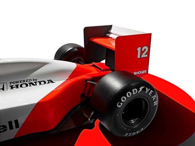 A close-up of a Formula 1 car's rear wheel, with a red and white McLaren car's rear wheel and tyre visible, with the McLaren logo on the side of the car.