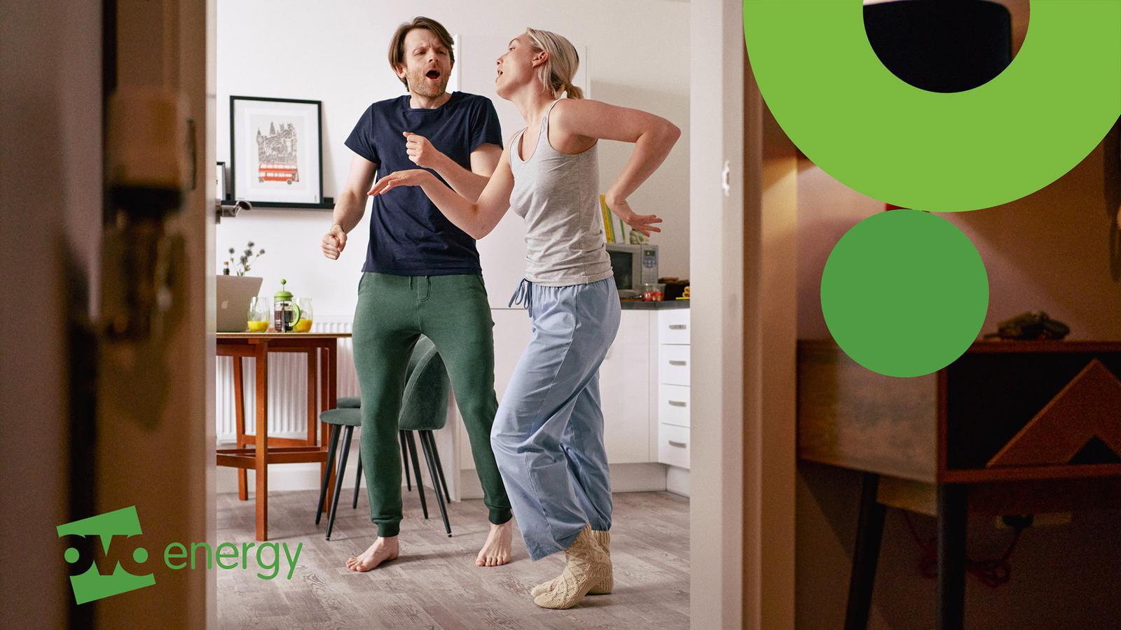 Two people dancing in a home office, wearing casual clothing and no shoes.