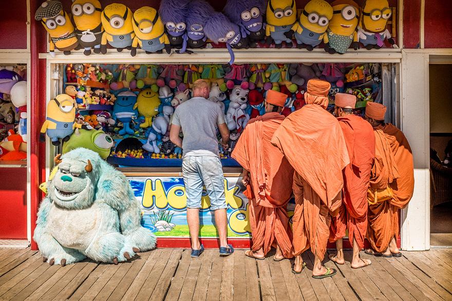 A man stands in front of a store window displaying stuffed animals and a blue monster from Monsters Inc.
