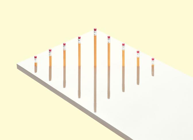 A collection of pencils standing upright in a row, each with a red cap on top, on a white background.