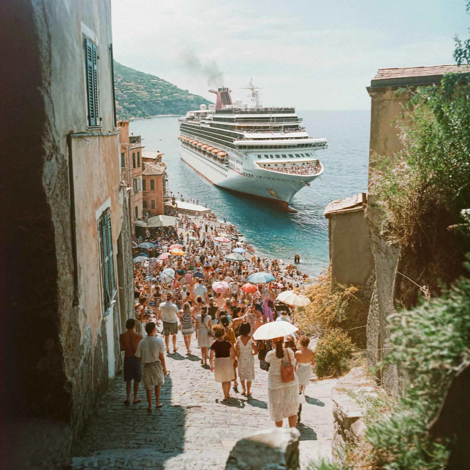A large cruise ship docked in a Mediterranean port with historic buildings and busy streets nearby.