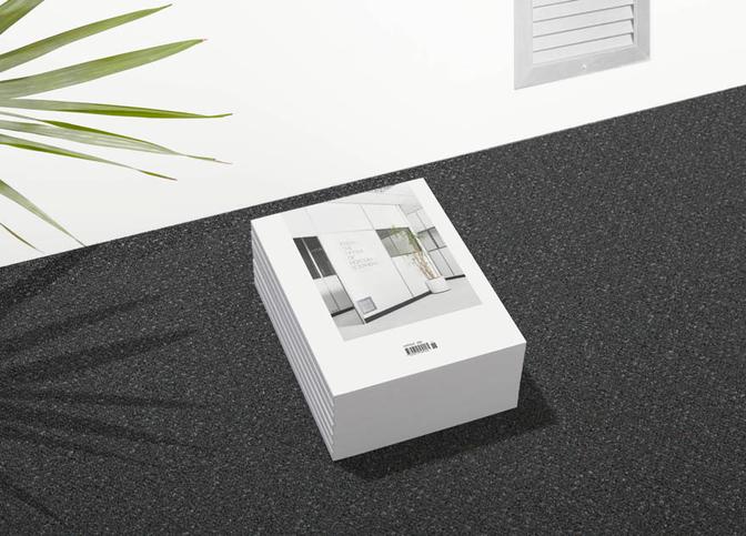 A stack of books with a cover featuring a modern office interior, likely a design or architecture book.