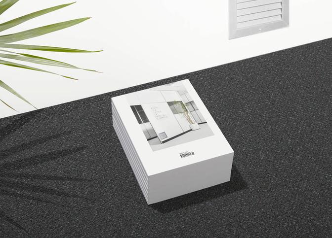 A stack of books with a cover featuring a modern office interior, likely a design or architecture book.