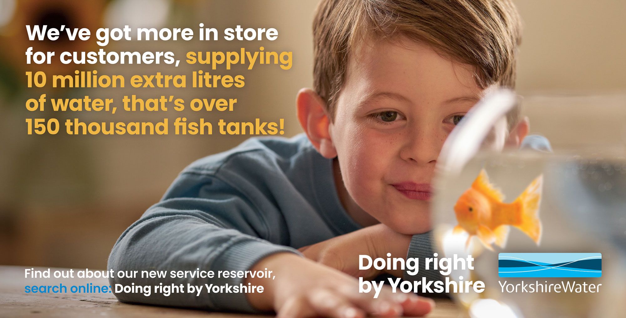 A young boy is looking at a goldfish in a fish tank.