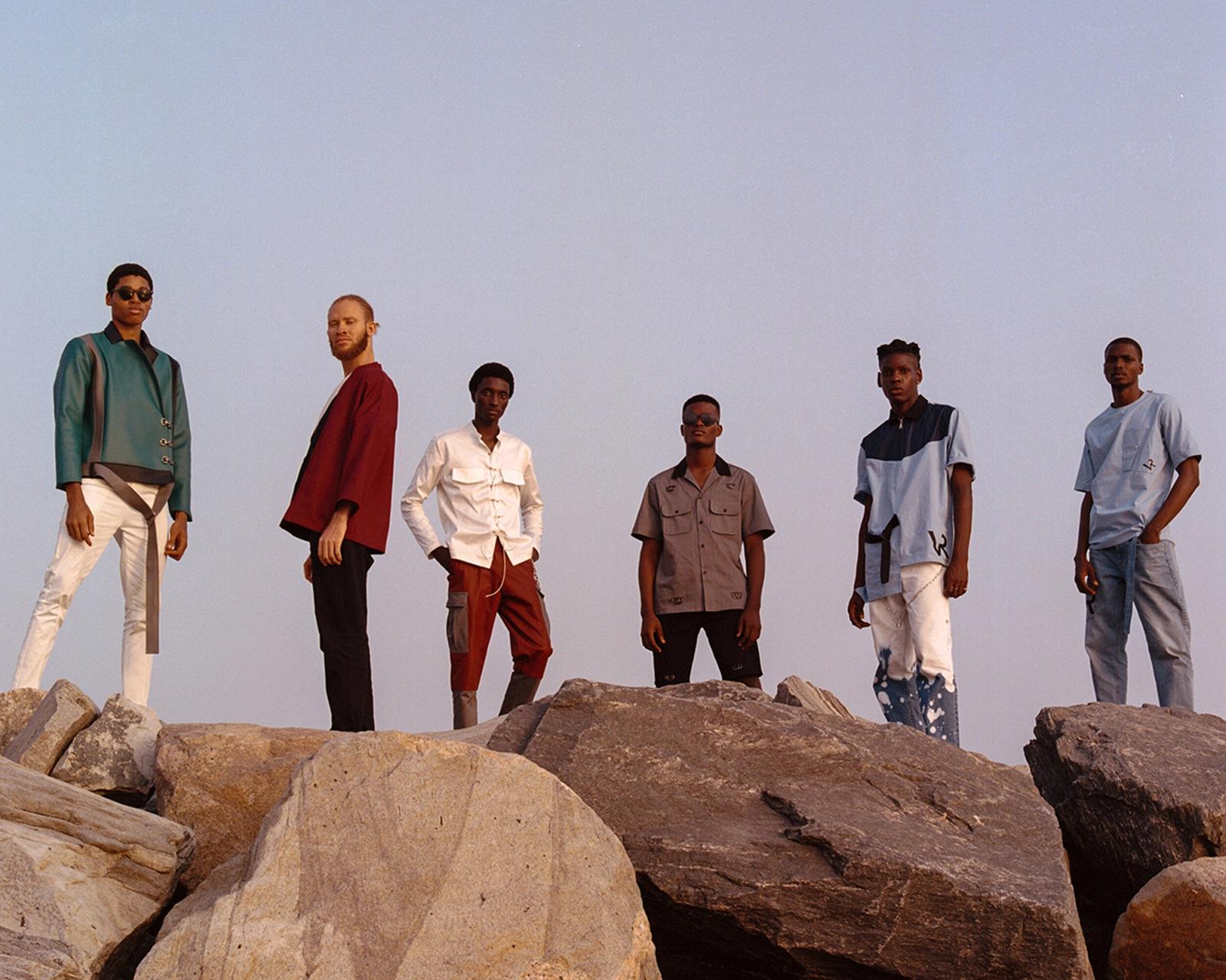 Six men standing on large rocks.