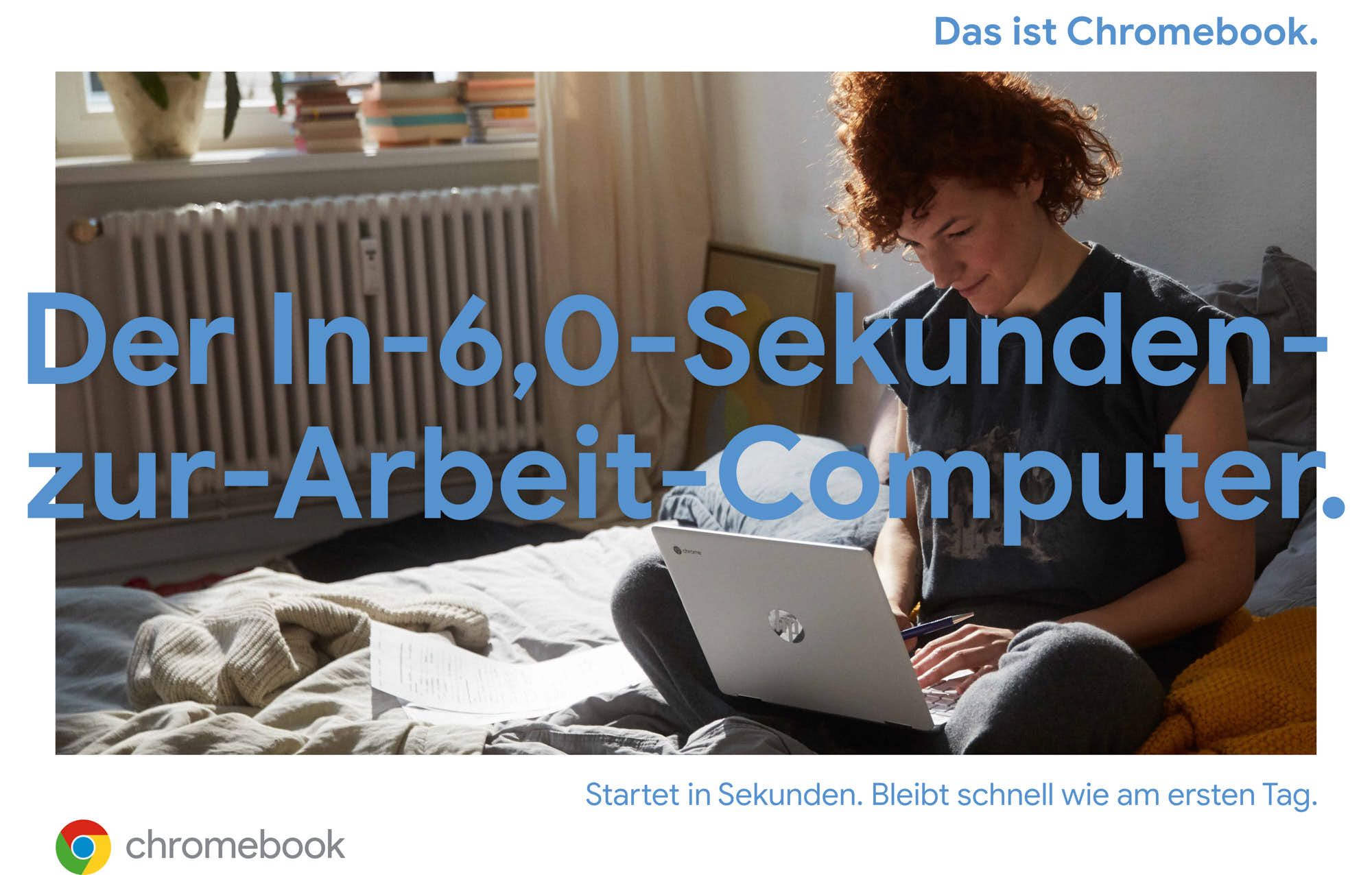 A woman with short, curly red hair sits on a bed with a laptop on her lap. She is wearing a dark grey t-shirt and grey pants, and has a pen in her hand. The room is well-lit,.