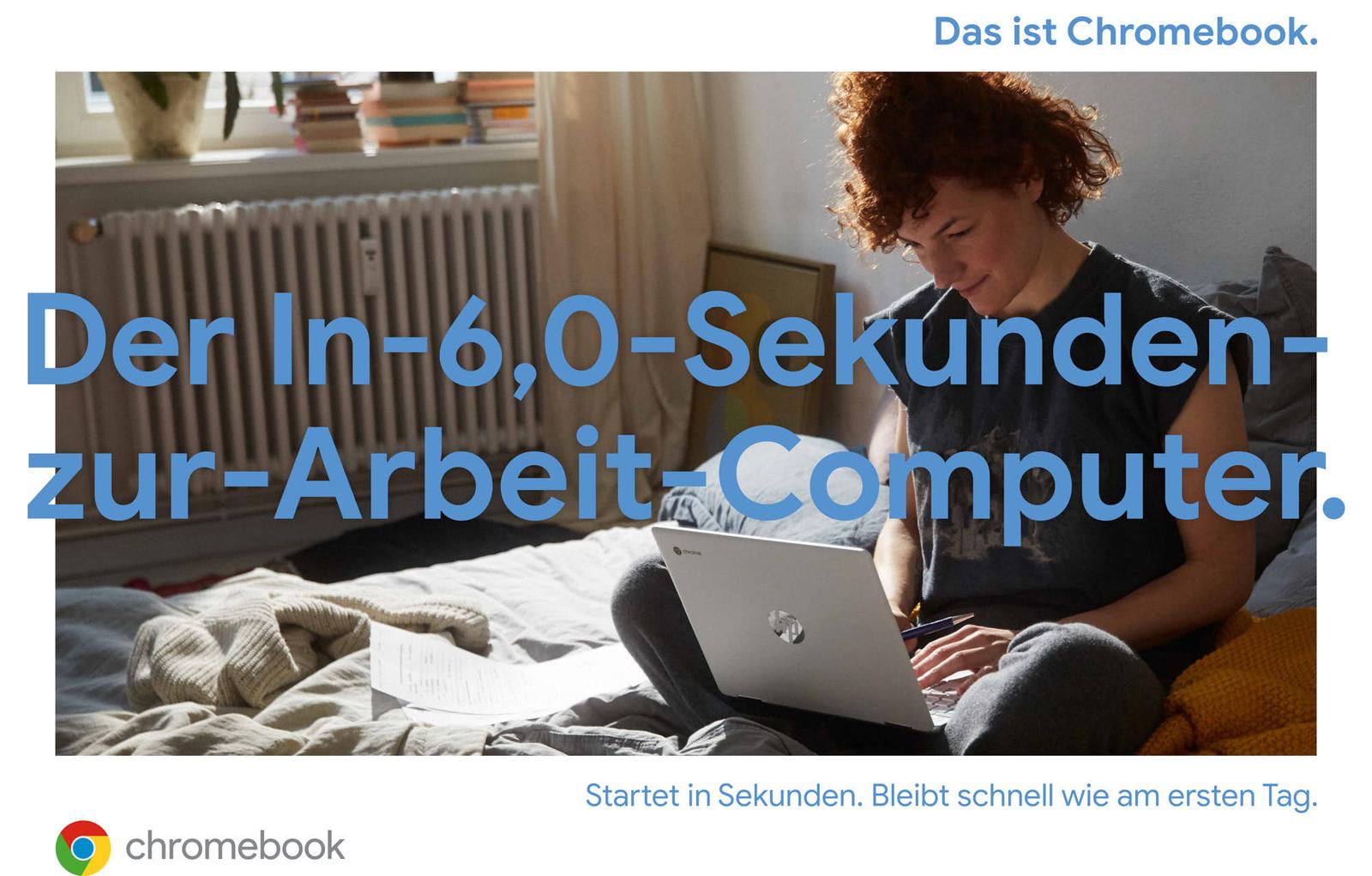 A woman with short, curly red hair sits on a bed with a laptop on her lap. She is wearing a dark grey t-shirt and grey pants, and has a pen in her hand. The room is well-lit,.