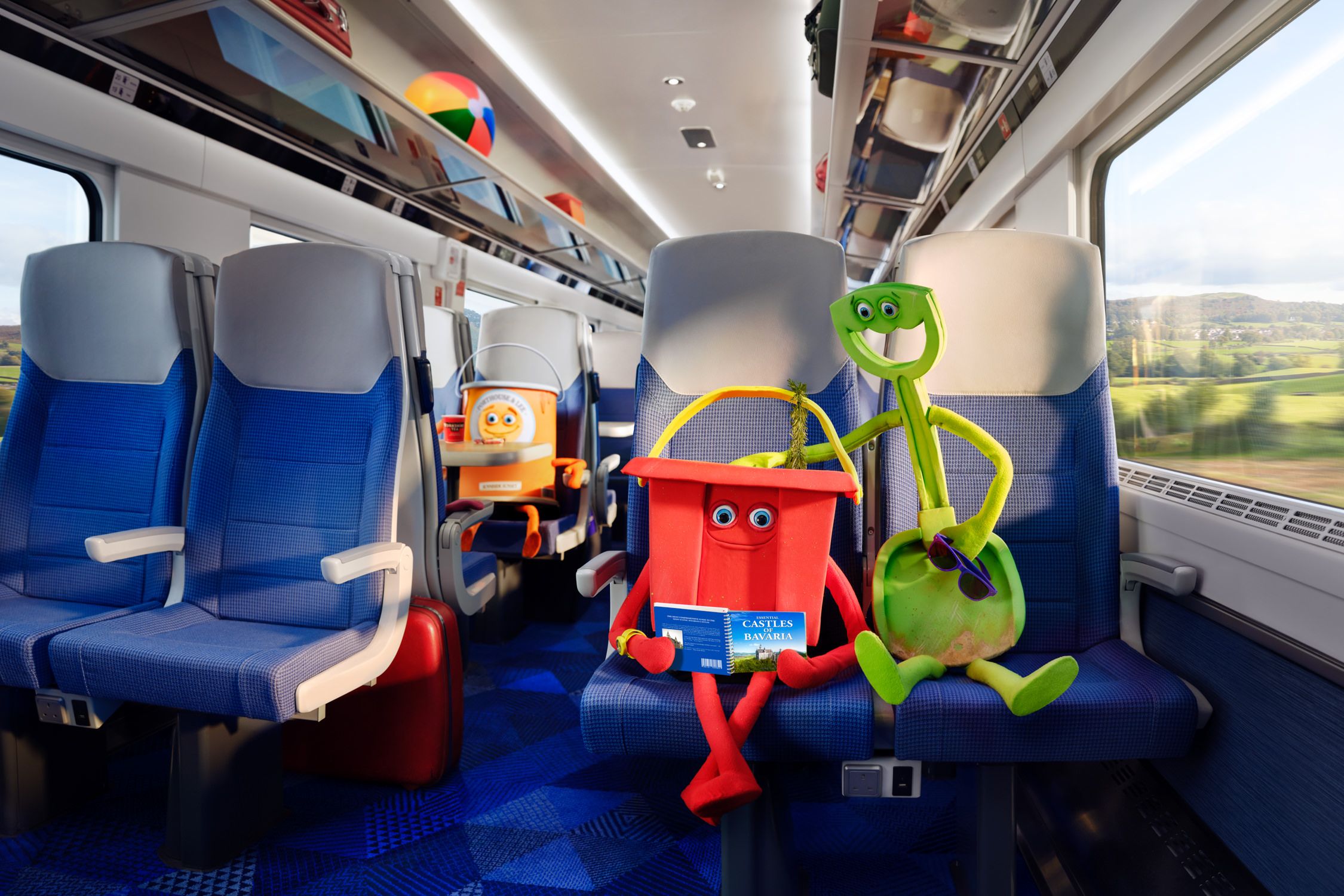 A train car interior with blue and white seats, and a few people in the background.