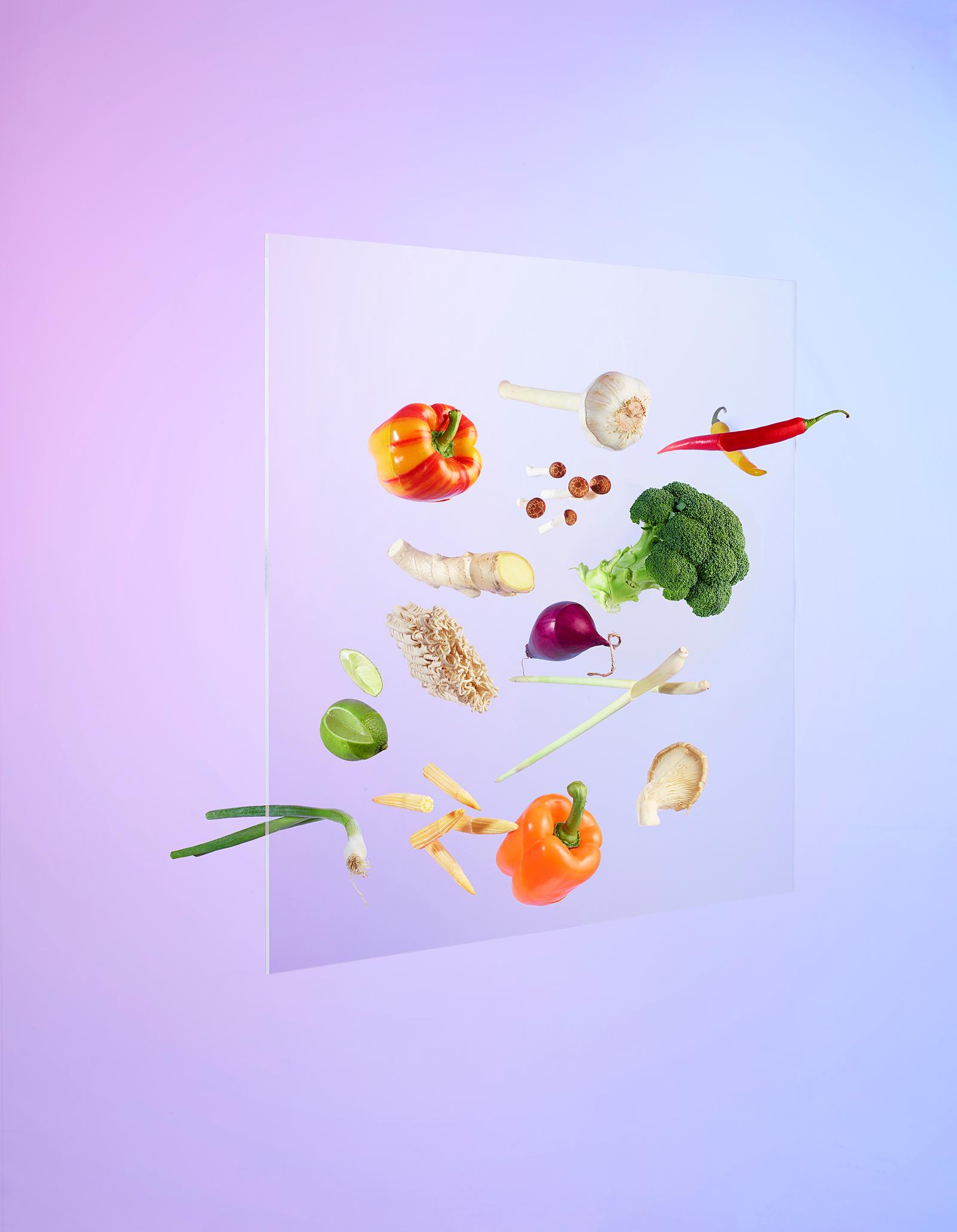 A collection of various vegetables and fruits, including a bell pepper, broccoli, and a lime, arranged in a collage-style image.
