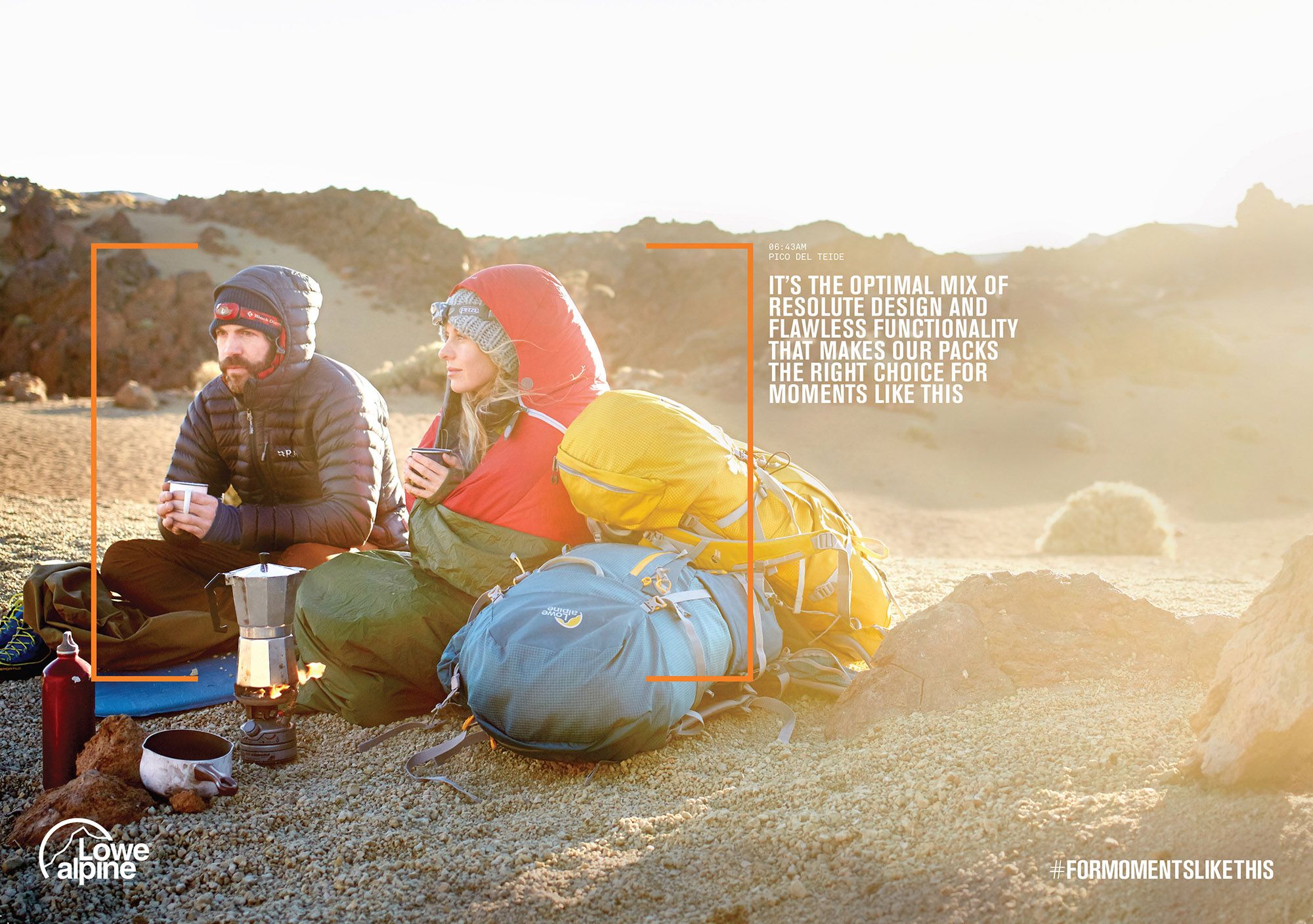 Two people sitting on a rocky outcrop with a campfire and coffee maker in the foreground.