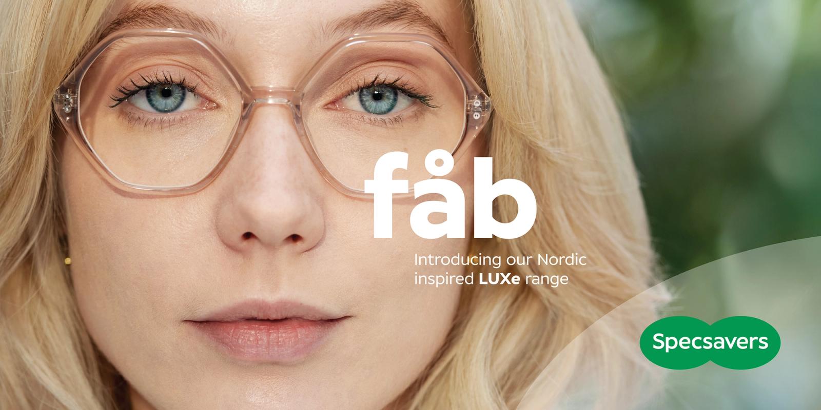 A woman with long blonde hair wearing a pair of glasses with a clear frame and a subtle, rounded shape, with a focus on her face and eyes.