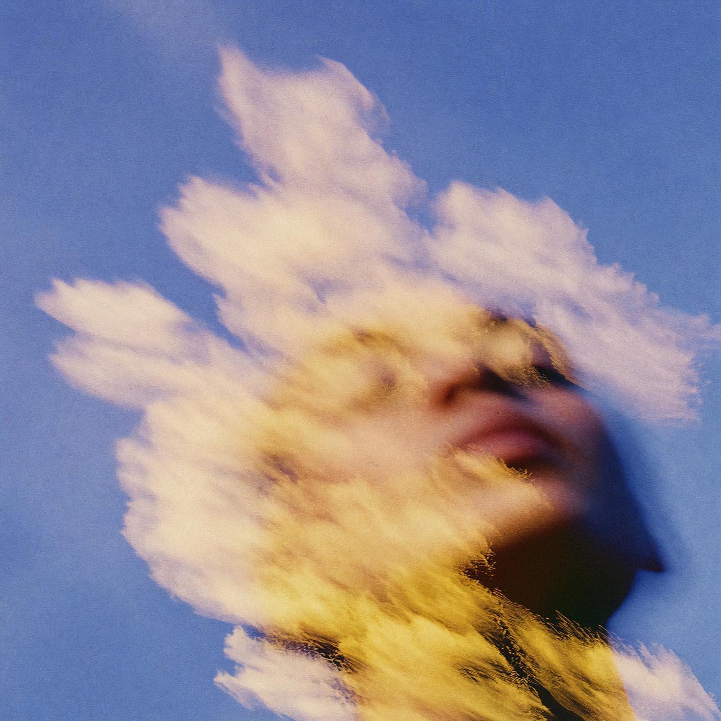 A woman with a cloud-like, wispy, white hairdo and a face that is partially obscured by a large, fluffy cloud.