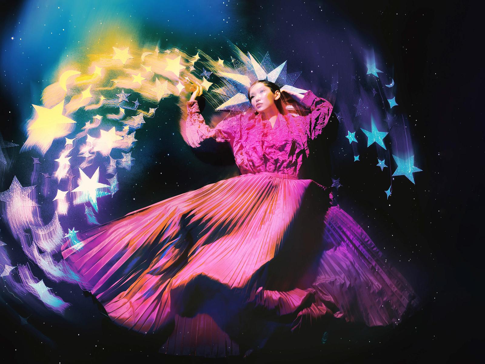 A woman in a pink, long-sleeved, ruffled blouse and a full, pleated, pink skirt, surrounded by stars and a crescent moon in the sky.