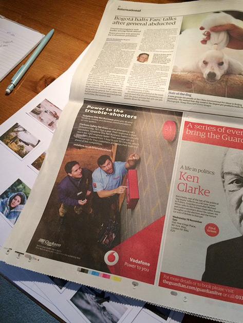 A newspaper page featuring a large image of a man in a suit and tie with a headline about a Vodafone ad.