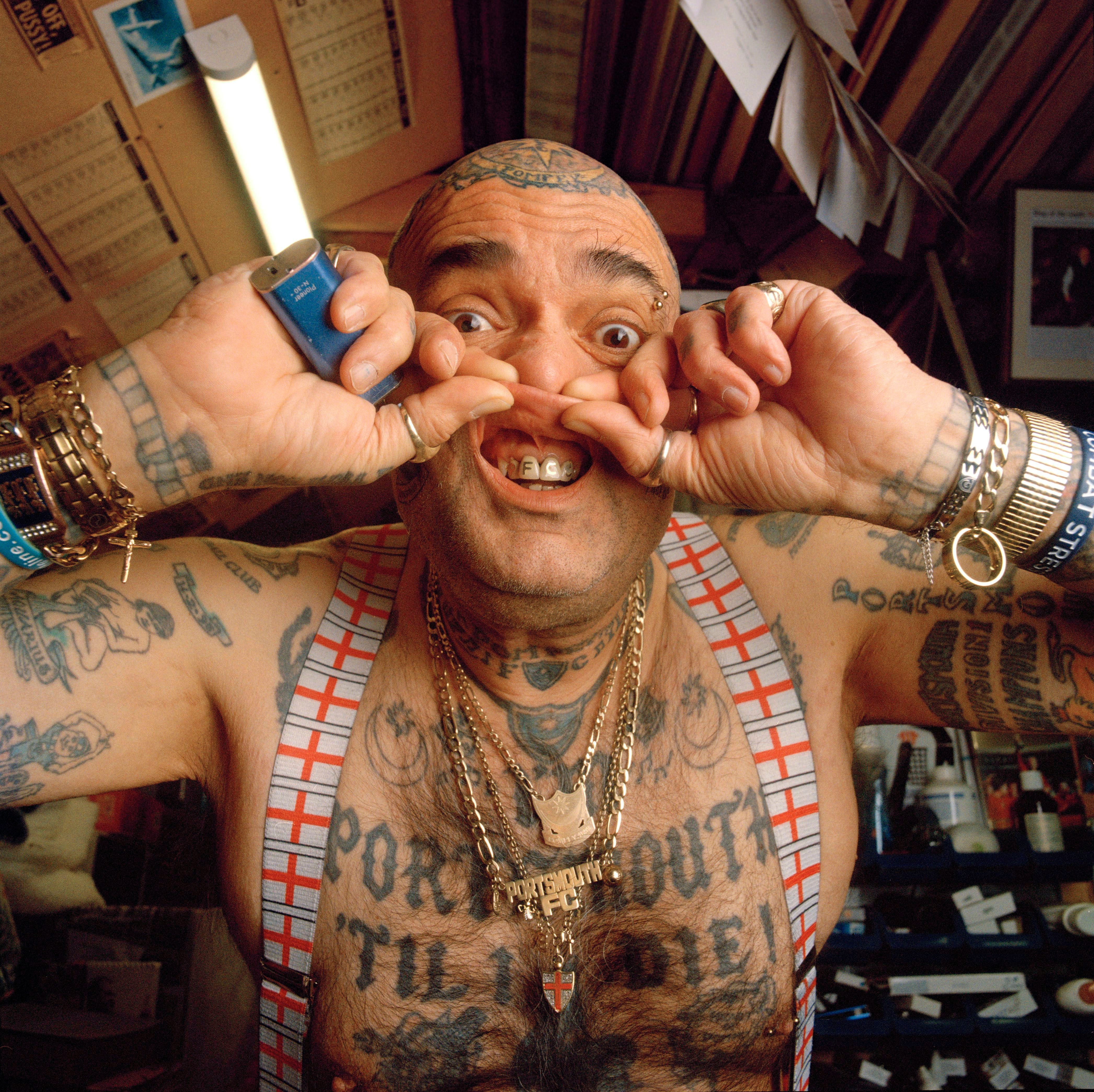 v2 A man makes a provocative face while wearing a football jersey and a chain.