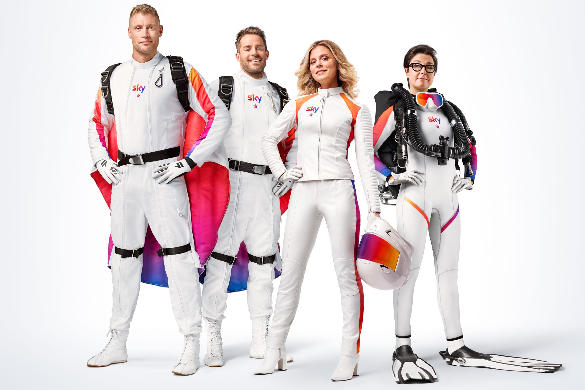 Four people in white and red skydiving suits, one with a scuba diving tank, and another with a helmet.