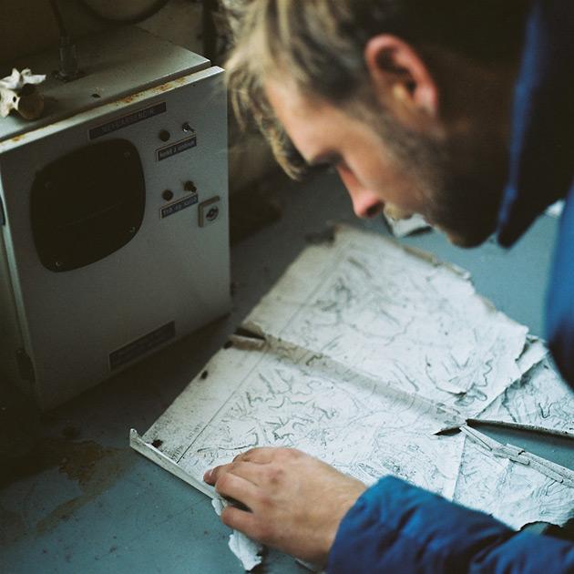 A man studies a worn map on a table.