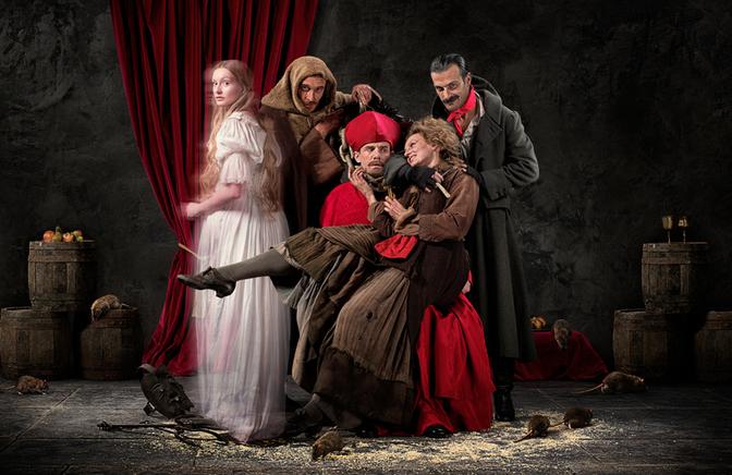 A group of people, including a woman in a white dress, a man in a red hat, and a man in a brown coat, are surrounded by rats and are in a dark, dungeon-like setting.