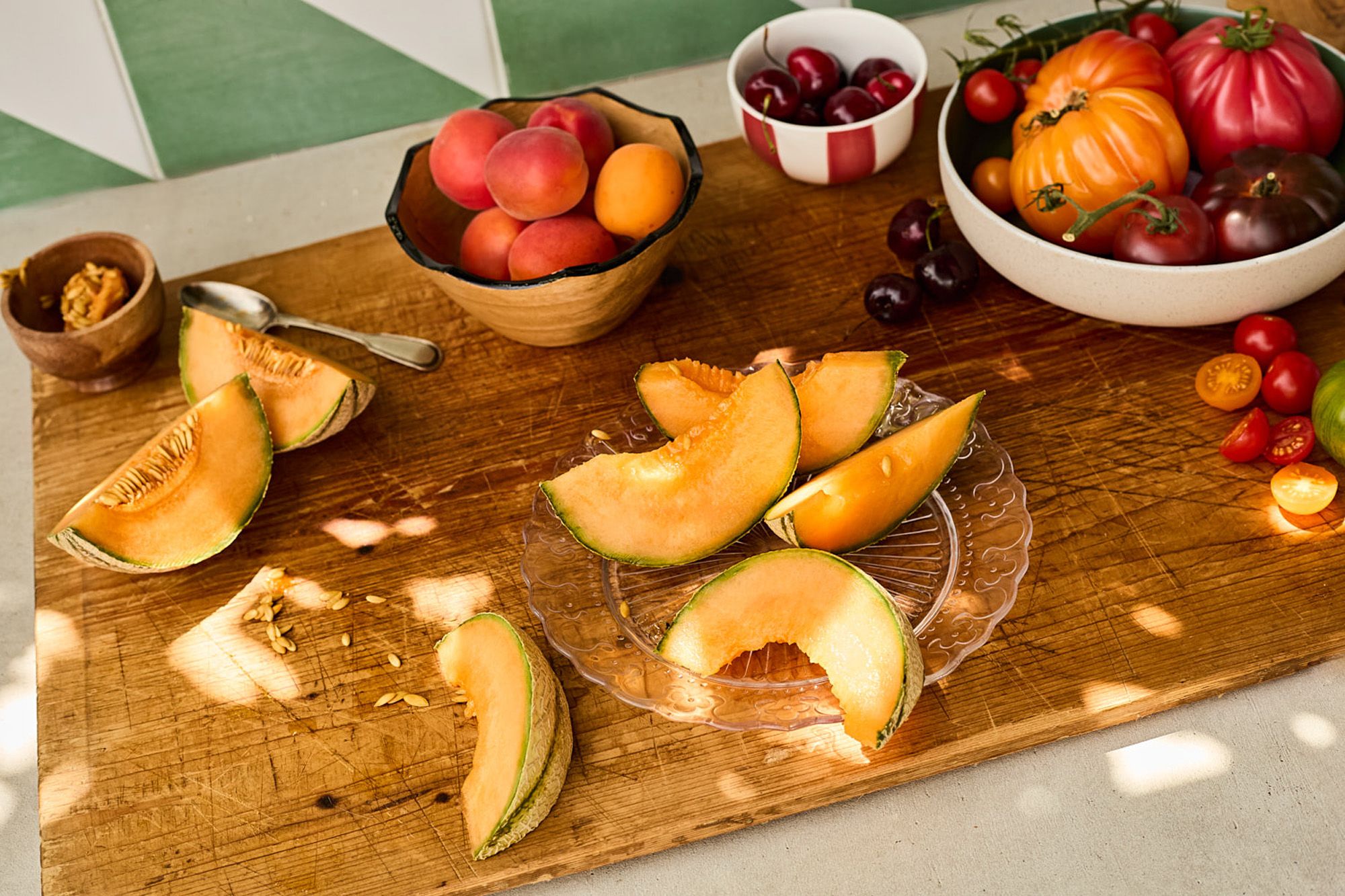 A table filled with fruits, vegetables, and flowers in a garden setting.