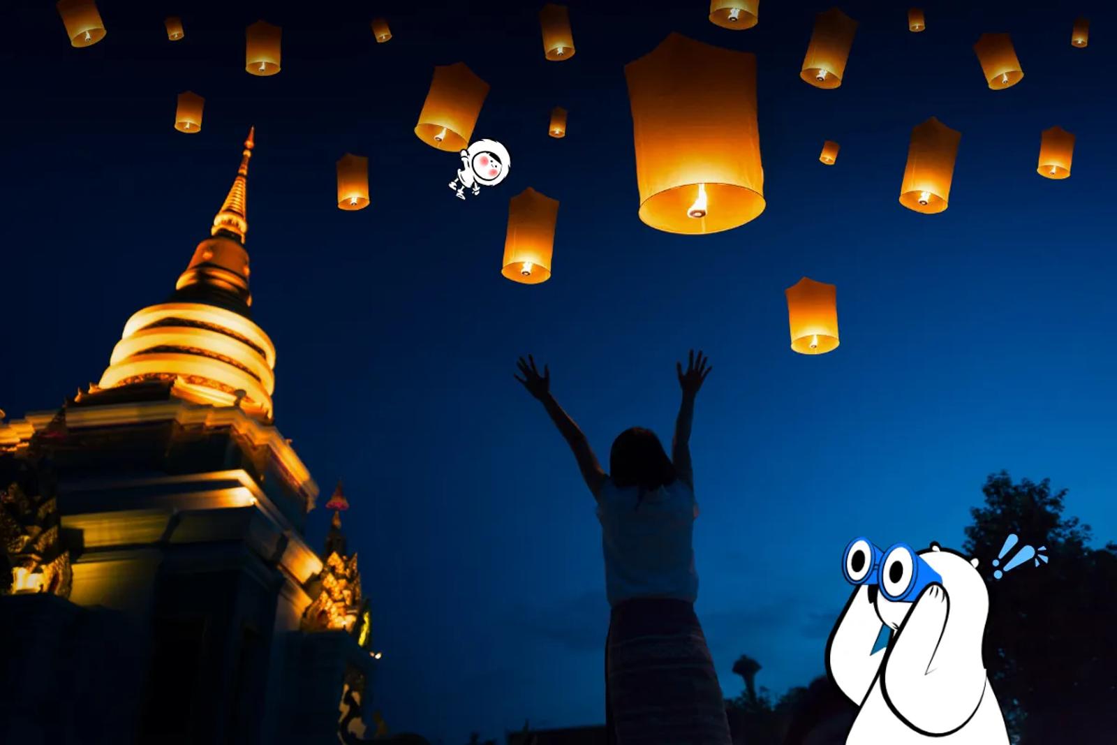 Traveler releasing sky lanterns during Yi Peng Festival at a temple in Chiang Mai, Thailand.