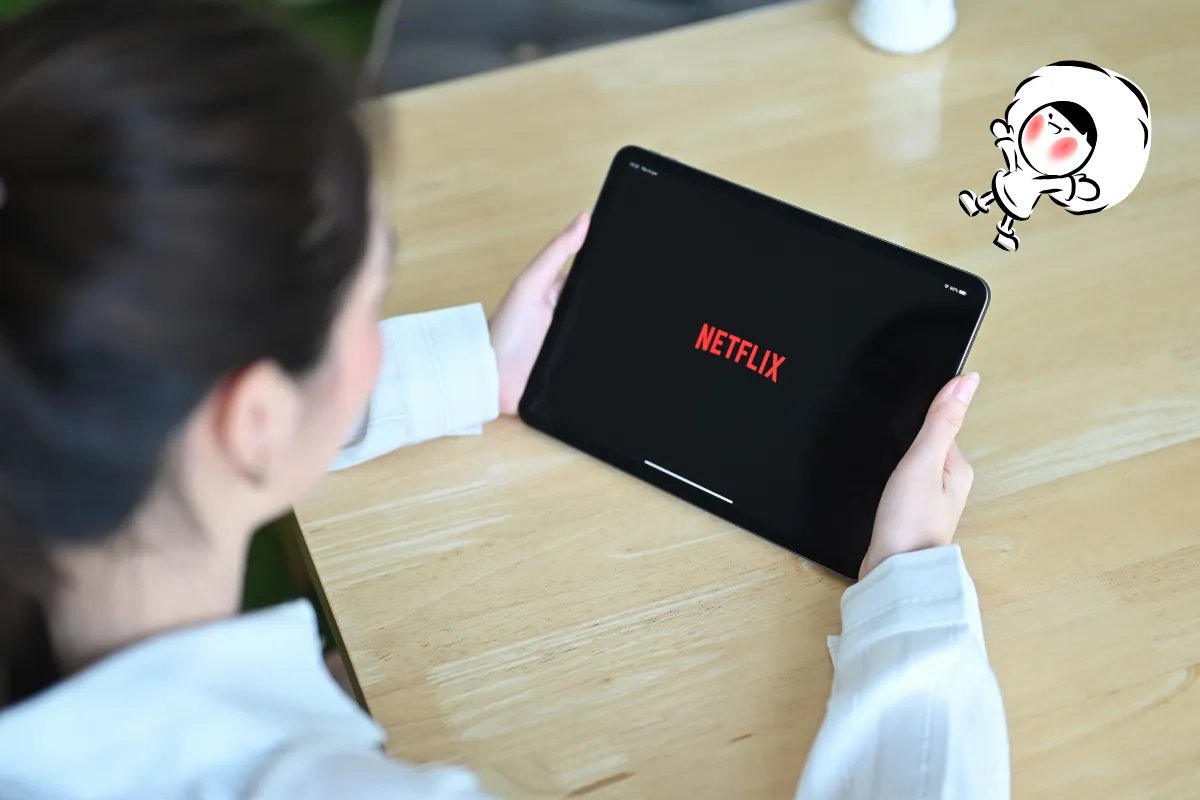 Cómo descargar series y películas de Netflix en laptop, Macbook y más. Mujer sosteniendo una tableta con el logo de Netflix en la pantalla