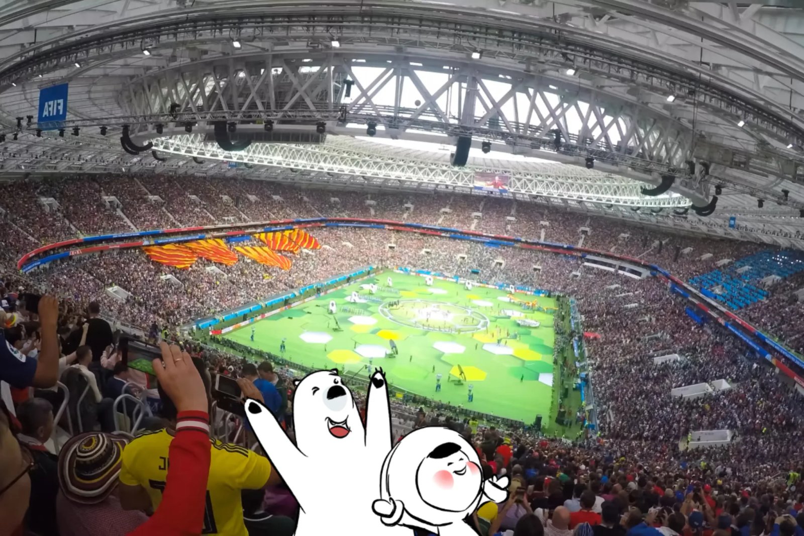 A packed football stadium during a major tournament ceremony, with a brightly lit pitch, large crowd in the stands, and colorful pre-match displays on the field.
