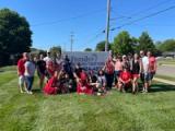 The Family Audiology and Hearing Centers team gathered on the lawn beside the practice sign
