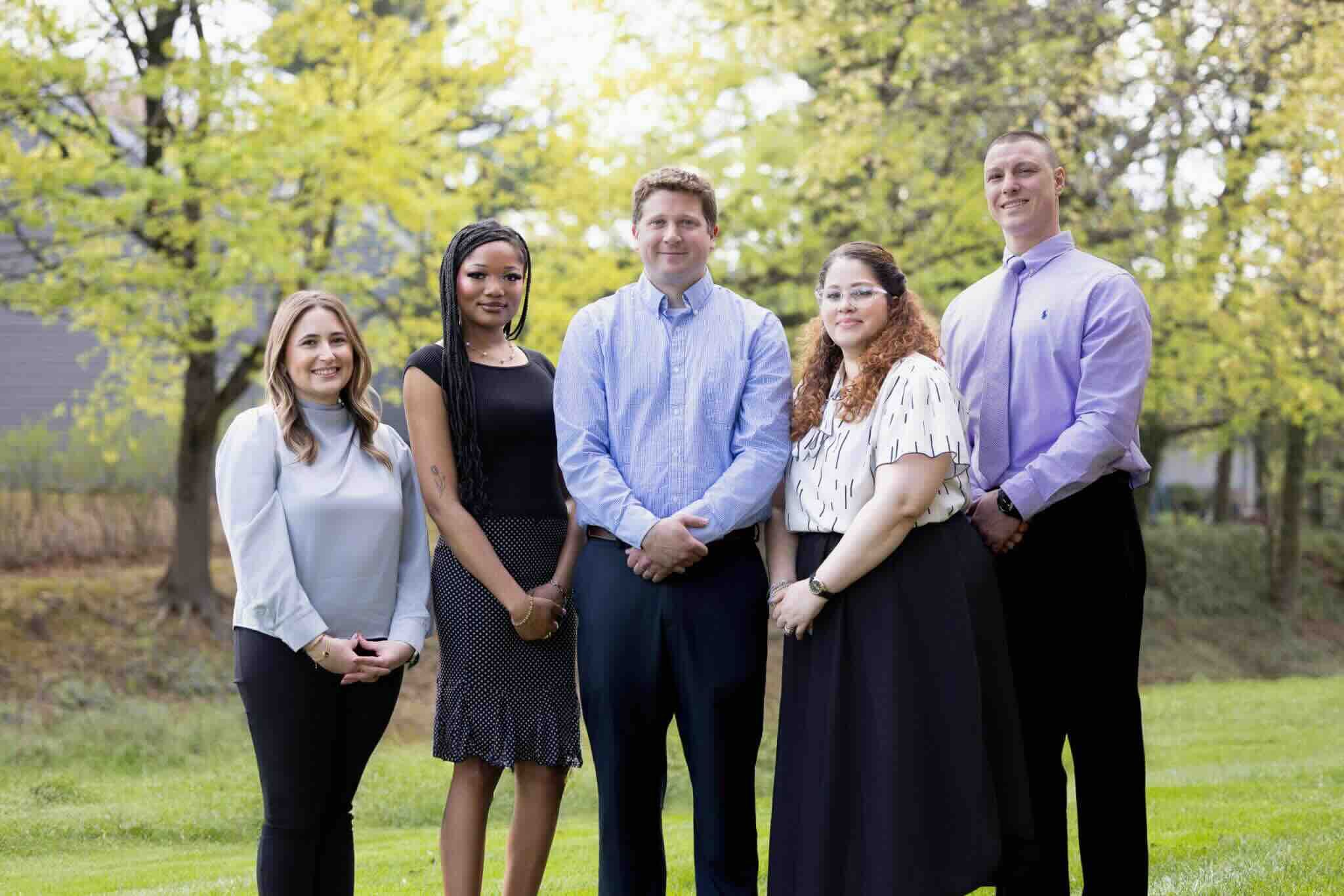Five members of the Kleckner Tinnitus team standing outdoors under trees