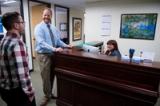 Staff chatting with a visitor at the front desk of The Hearing Clinic