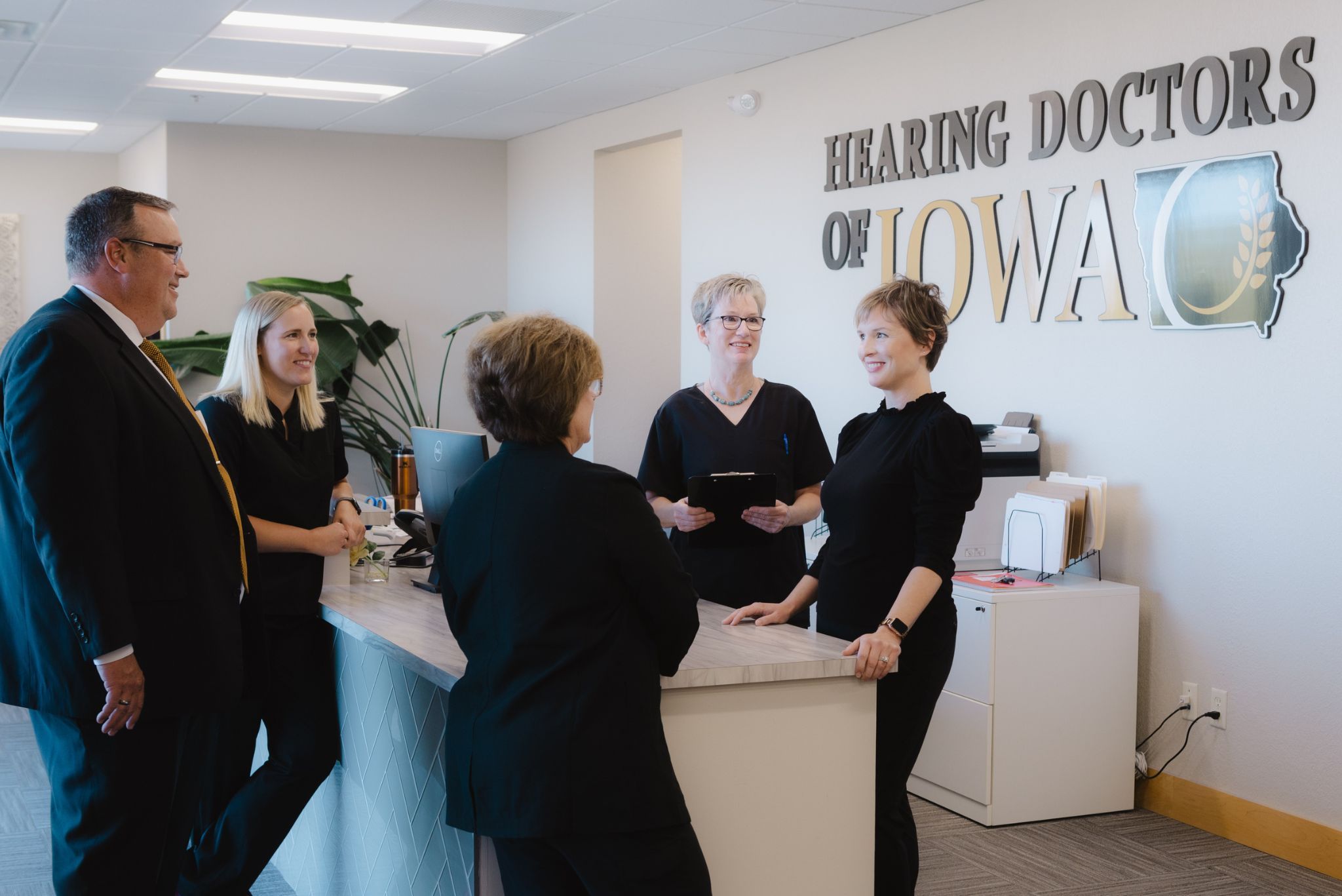 The Hearing Doctors of Iowa team talking at the front desk