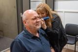 An audiologist looking into a patient's ear with an otoscope