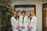 Three clinicians in white coats in the Colorado Tinnitus and Hearing Center lobby